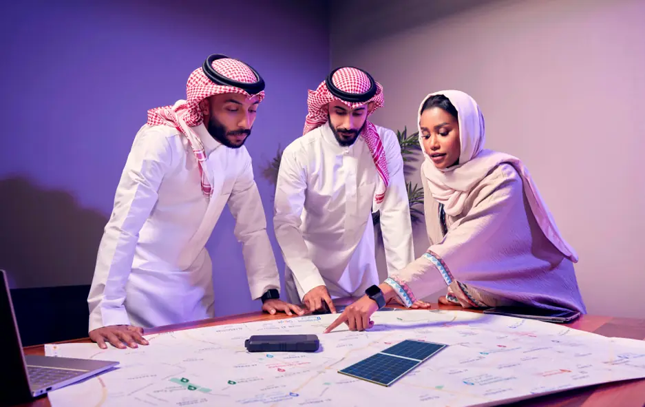 Saudi advisory team reviewing a strategic planning map